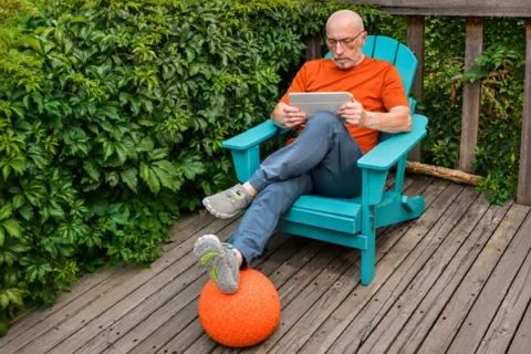 Senior man reading a tablet on a porch