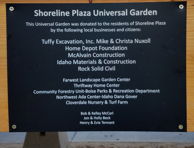 Dedication plaque titled "Shoreline Plaza Universal Garden" recognizing local businesses and community members who donated the garden.
