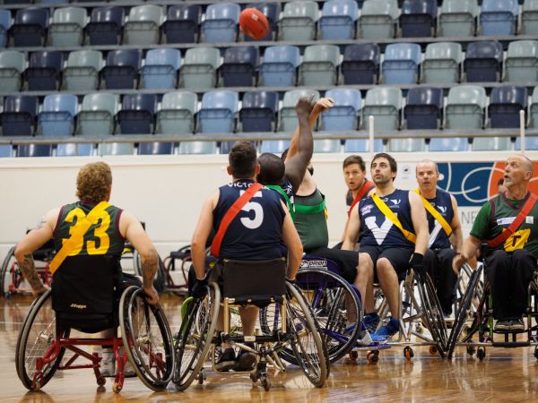  American football players in wheelchairs on an indoor court