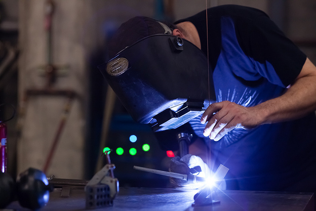 Person wearing a welding helmet using welding equipment to fuse two pieces of metal together. This image is for illustrative purposes only and does not depict individuals in the story.